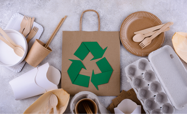 recycle-symbol-printed-on-a-paper-bag-surrounded-by-recycable-materials